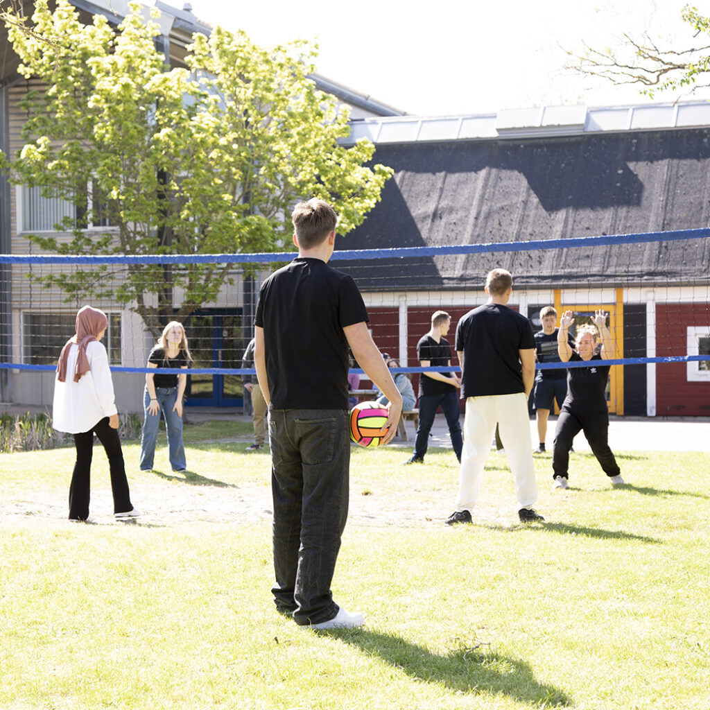 Elever fra NEG Kalundborg nyder det gode vejr og spiller volleyball udenfor.